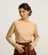 Blusa de punto color blanco, con cuello alto, manga larga y diseño liso.