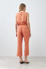 Pantalón celeste de lino, corte recto, con efecto desflecado en el ruedo.