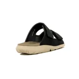 Sandalia tipo slide de hombre, color negro, con dos tiras ajustables mediante velcro. La suela es gruesa y de color beige claro, con relieve en la parte inferior.