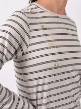 Remera de manga larga color azul oscuro con estampado de pequeñas hojas o puntos en blanco/gris claro. Presenta detalles de botones dorados en el escote del hombro.