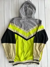 Campera deportiva con capucha, color gris, beige, negro y amarillo.