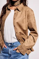 Camisa color marrón de gamuza sintética, de corte recto, con cuello clásico, cierre frontal con botones y mangas largas.