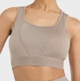 Top deportivo Umbro color beige con pretina diferenciada con la leyenda "PRO TRAINING" y transparencias de mesh en el pecho.