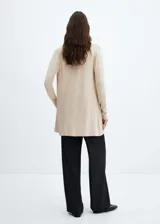 Cárdigan color beige de tejido de punto fino, diseño recto, cuello pico y manga larga.