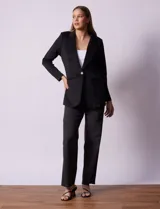 Blazer color beige, entallado, con cuello con solapa, abertura central con botón y bolsillos delanteros.