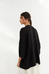 Kimono negro de tejido calado con mangas anchas.