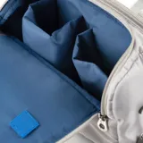 Bolso matero gris acolchado con correa ajustable y doble asa de mano. Tiene cierre doble, dos bolsillos externos con cierre, un bolsillo interno con cierre y dos bolsillos internos abiertos. El interior es de tela de algodón y poliéster y tiene compartimentos para notebook y matero.
