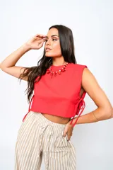 Top rojo sin mangas con cuello redondo y laterales abiertos con lazos.