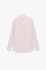 Camisa de cuello solapa y manga larga con puño doble abotonado. Cierre frontal con botones y estampado a rayas verticales rosas y blancas.