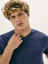 Pijama de dos piezas compuesto por remera manga corta gris con cuello en V y bordado de logo en el pecho, y short negro.