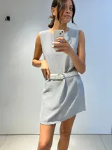 Vestido corto sin mangas, con cuello redondo y corte recto, confeccionado en tejido de lino a rayas verticales blancas y azules.