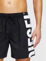 Short de baño negro liso, con cordón ajustable en la cintura y detalle de franjas oscuras en el lateral derecho.