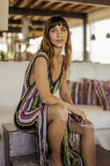 Vestido largo tejido a crochet con rayas verticales multicolores y flecos en el ruedo.