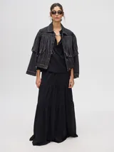 Camisa de broderie de algodón color negro, con cuello mao y cierre de cuatro botones. Presenta mangas abullonadas y galones con transparencias en la parte delantera y mangas.