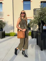 Bandolera de hombro color gris claro, con solapa frontal y correa ajustable. Presenta un diseño simple y práctico, ideal para uso diario.