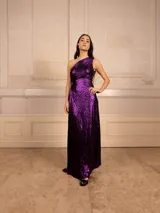 Vestido largo de fiesta color violeta metalizado, con textura plisada y diseño de un solo hombro.