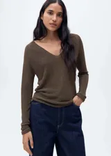 Jersey de punto fino color verde esmeralda con cuello pico y manga larga. Tejido con lurex.
