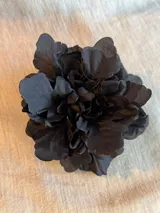 Accesorio para el pelo en forma de flor de tela color negro, con broche francés.
