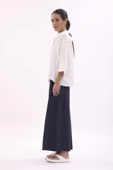 Camisa holgada de lino color rosado, con cuello camisero, manga 3/4 y botones frontales.