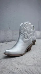 Bota corta plateada de estilo texano con bordados en el caño, taco de madera y cierre lateral.