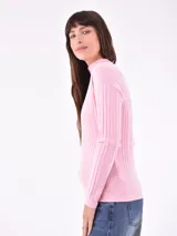 Polera rosa de tejido canalé, con cuello alto y mangas largas.