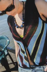 Chaleco calado con diseño de rayas diagonales en tonos azul, amarillo y rojo. Se puede usar de ambos lados, solo como musculosa o sobre una remera o camisa.