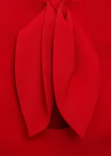 Top corto rojo con cuello redondo, sin mangas y espalda abierta con cierre de lazo.