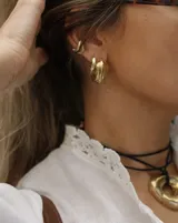 Aro earcuff plateado y dorado con diseño texturizado que simula lava.