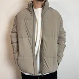 Campera puffer color beige con cierre frontal y cuello alto. Diseño acolchado con bolsillos laterales.