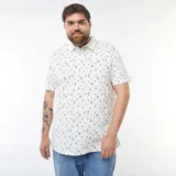 Remera polo blanca de piqué con estampado de palmeras, tablas de surf y sombrillas.