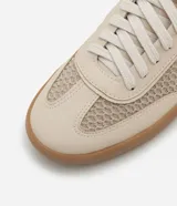 Championes color beige con detalles en blanco, de tela y cuero sintético, con suela marrón.