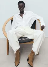 Bota corta de gamuza color marrón, con punta fina y tacón bloque de 8 cm. Cierre de cremallera lateral.