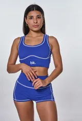 Conjunto deportivo azul eléctrico con costuras blancas. Incluye top deportivo con logo 'bk.' y shorts de tiro alto.