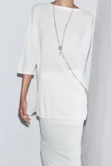 Falda midi color crema, de punto, con cintura elástica y forro interior corto.