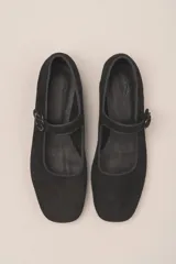 Zapato estilo Mary Jane color marrón, de cuero, con punta redondeada y tira sobre el empeine con hebilla.
