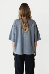 Remera gris oscuro de corte holgado con estampado de una estrella naranja en el pecho.