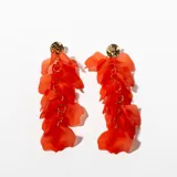 Aros colgantes con base redonda dorada y pétalos de acrílico rojos unidos por aros dorados.