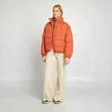 Campera puffer naranja con cuello alto, cierre frontal con cremallera y bolsillos laterales. Diseño acolchado con costuras en forma de rombos.