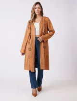 Chaqueta larga color marrón, de símil gamuza calada con diseño de flores y puntos. Tiene silueta abierta y mangas largas de corte recto.