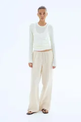 Pantalón de lino color crema, de corte holgado, con cintura elastizada y cordón de ajuste.