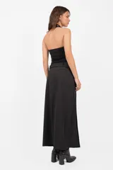 Top negro sin mangas con cuello halter, confeccionado en punto roma. Presenta escote embolsado con vista de algodón con lycra y elástico en su terminación para un mejor ajuste. Detalle de ojalillos color níquel en cuello y escote.