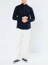 Camisa de popelina azul marino de Tommy Hilfiger, de manga larga, con cuello abotonado, cierre con botones y logo bordado en el pecho.