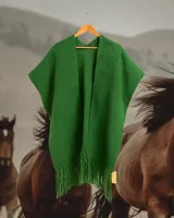 Ruana verde de tejido de punto con cuello en V y flecos en el ruedo.