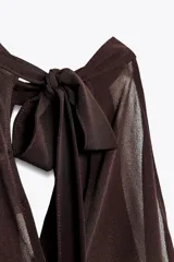 Top color rosa viejo de cuello halter ajustable con lazadas. Detalle de abertura en el delantero y volantes en el mismo tejido.