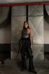 Top negro de encaje con cuello halter, espalda descubierta y flecos en el ruedo.