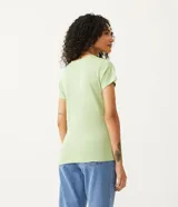 Blusa blanca de algodón con cuello en V, manga corta y bolsillo frontal.
