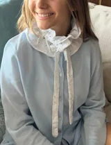 Cuello blanco de broderie con volados y lazos para atar.