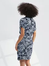 Vestido corto con estampado floral en tonos azul y blanco, con cuello en V, mangas cortas y lazo en la cintura.