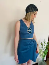 Falda corta cruzada color azul de gamuza, con lazo lateral.