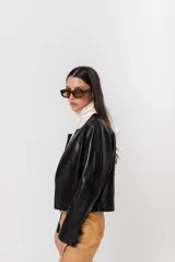 Chaqueta de cuero negra entallada, de largo a la cintura y acabado rústico. Sin forro.